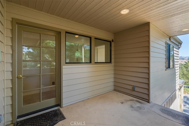 view of exterior entry with a patio area