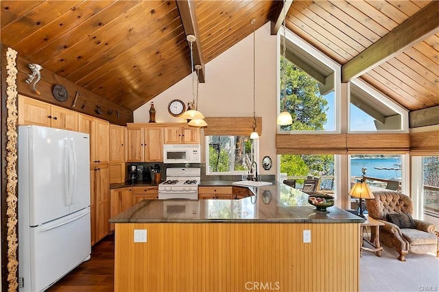 kitchen with beam ceiling, a wealth of natural light, white appliances, and dark hardwood / wood-style floors