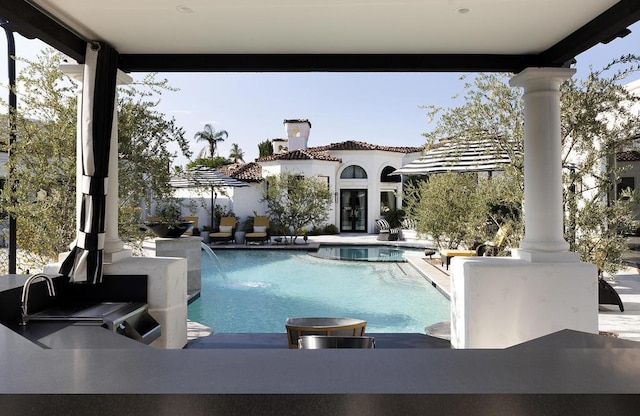 view of pool with pool water feature and a patio area