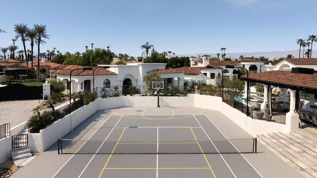 view of home's community with basketball hoop and tennis court