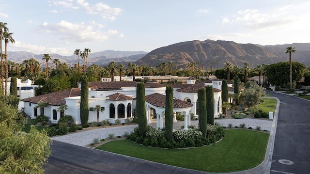 surrounding community with a mountain view and a lawn