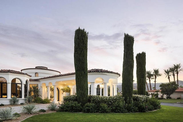 mediterranean / spanish house featuring a yard