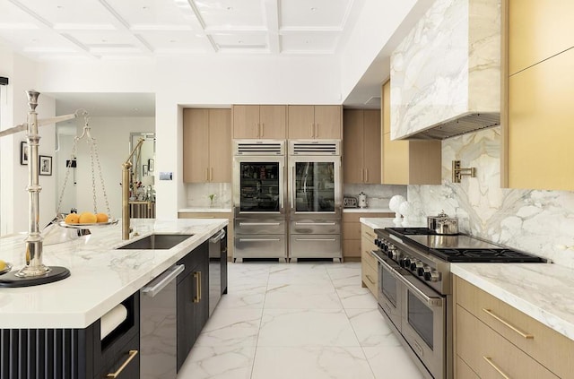 kitchen featuring stainless steel appliances, coffered ceiling, light stone counters, premium range hood, and decorative backsplash