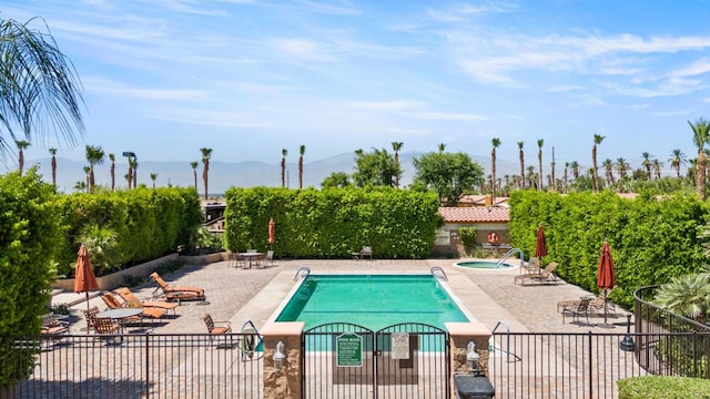 view of swimming pool with a mountain view and a patio