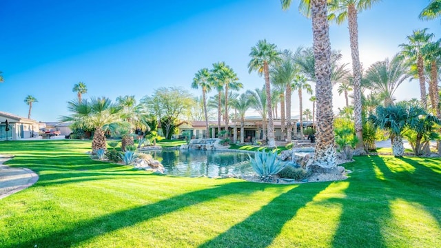 view of property's community with a lawn and a water view