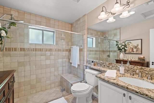 bathroom with a shower with shower door, vanity, plenty of natural light, and toilet