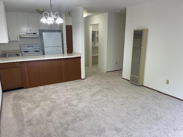 kitchen with white appliances, range hood, a notable chandelier, white cabinets, and decorative light fixtures