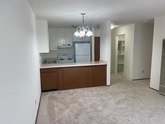 kitchen featuring white cabinetry, decorative light fixtures, a chandelier, light carpet, and white appliances