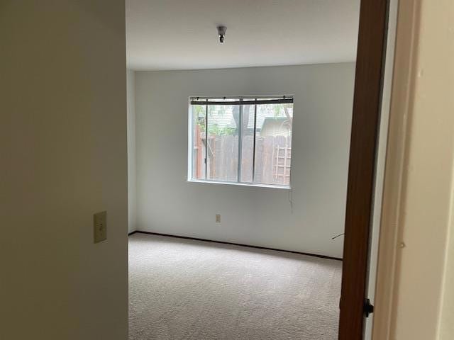 unfurnished room featuring light colored carpet