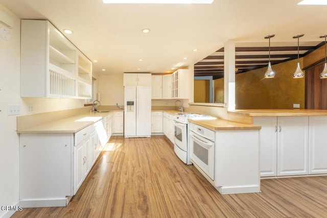 kitchen featuring white cabinetry, sink, light hardwood / wood-style floors, and white appliances