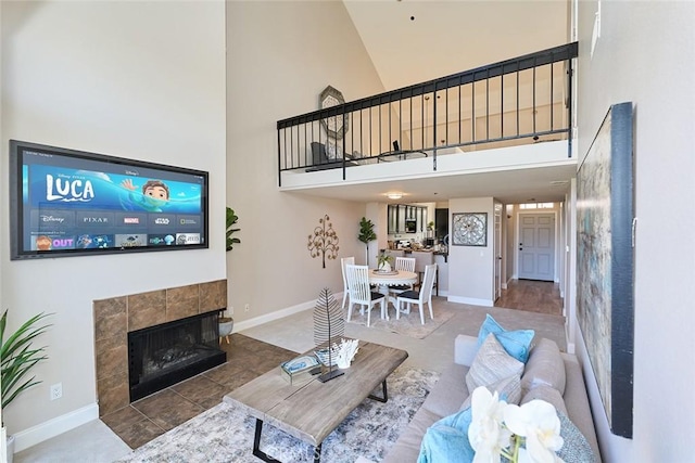 living room featuring high vaulted ceiling and a tile fireplace