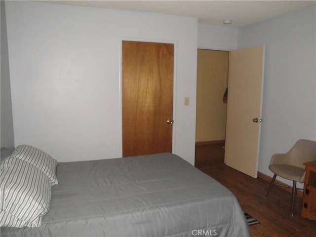 bedroom with dark wood-type flooring