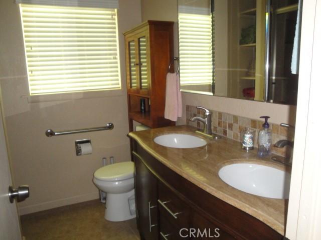 bathroom with tasteful backsplash, vanity, and toilet