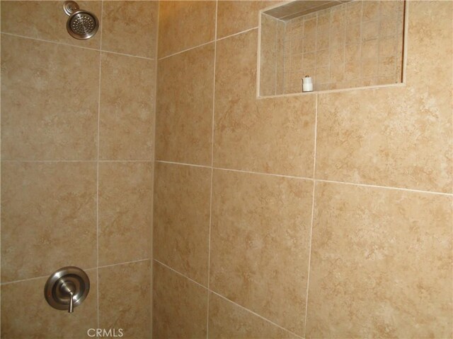 interior details with a tile shower