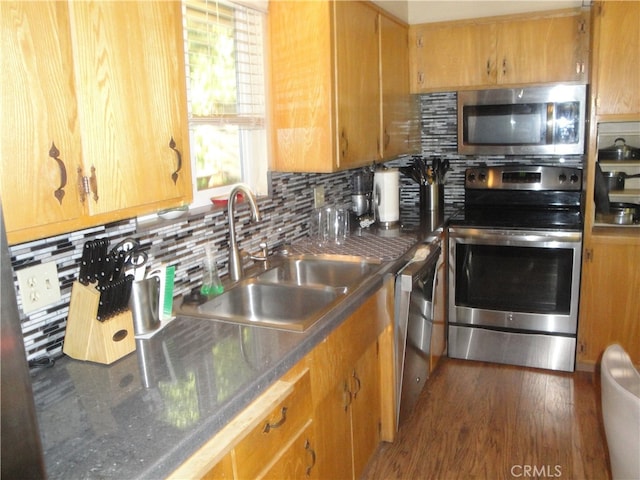 kitchen featuring tasteful backsplash, sink, stainless steel appliances, and dark hardwood / wood-style flooring