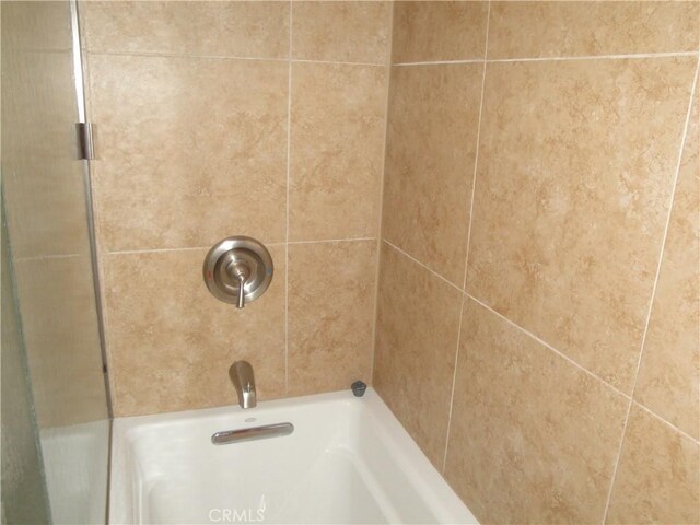 interior space with tiled shower / bath combo