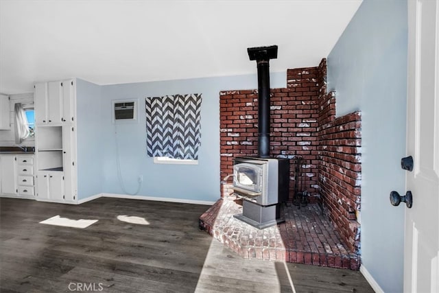 interior space with hardwood / wood-style floors, a wood stove, and a wall mounted AC