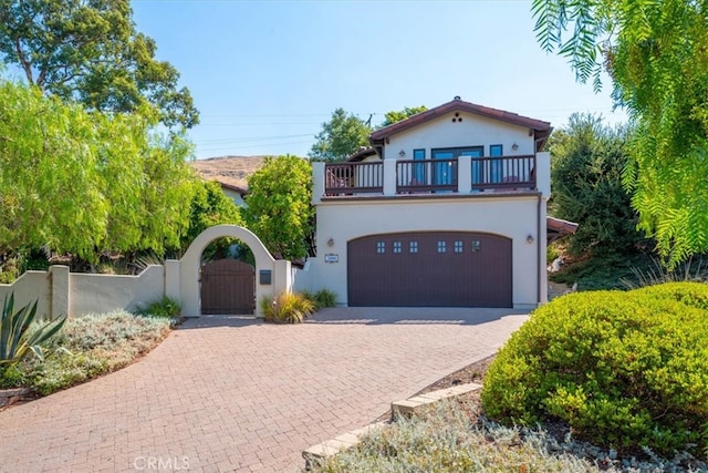 mediterranean / spanish-style home with a balcony and a garage