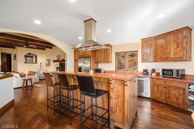 kitchen featuring vaulted ceiling with beams, a kitchen island, island range hood, dark wood-type flooring, and stainless steel appliances