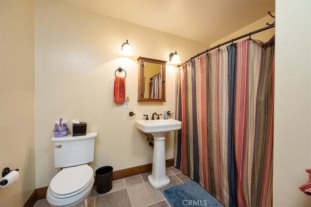 bathroom with tile patterned flooring, vaulted ceiling, and toilet