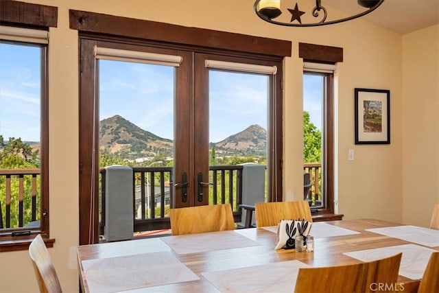 dining area with a healthy amount of sunlight, a mountain view, and french doors