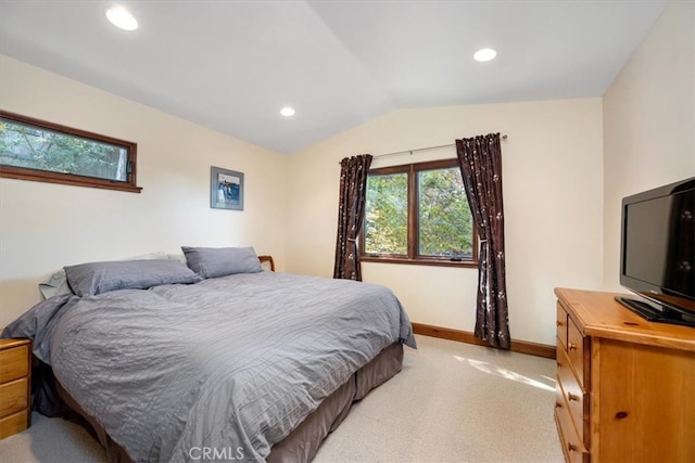 bedroom featuring light carpet and vaulted ceiling