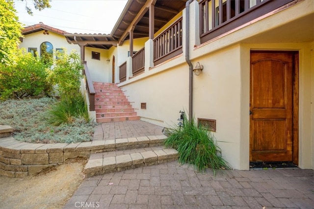 view of exterior entry featuring a balcony