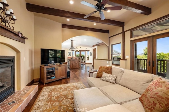 living room with a fireplace, beamed ceiling, ceiling fan, french doors, and hardwood / wood-style flooring