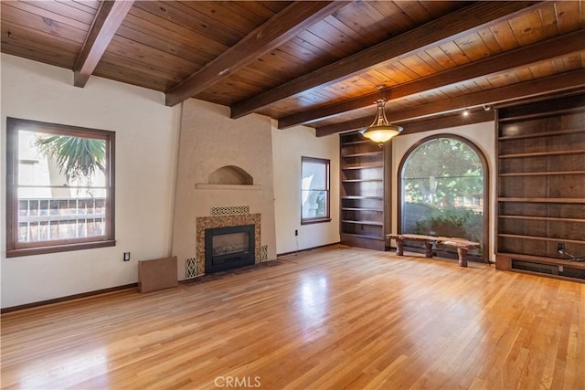 unfurnished living room with wood ceiling, a wealth of natural light, and built in features