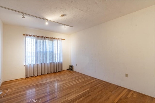 unfurnished room featuring hardwood / wood-style floors and a textured ceiling