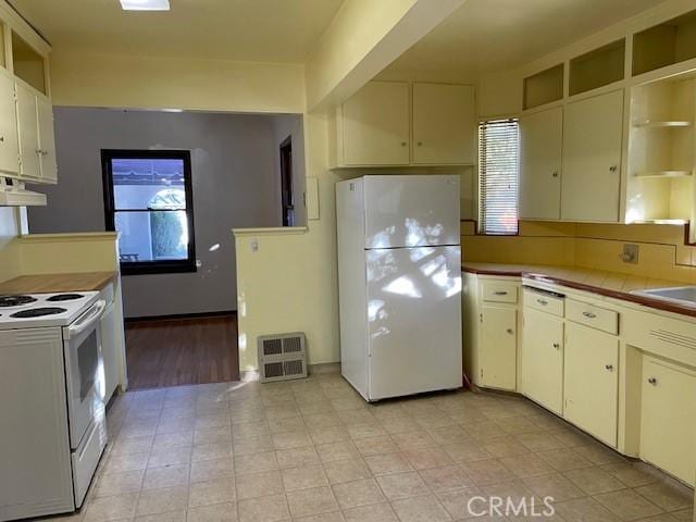 kitchen featuring tasteful backsplash, sink, white appliances, and cream cabinets