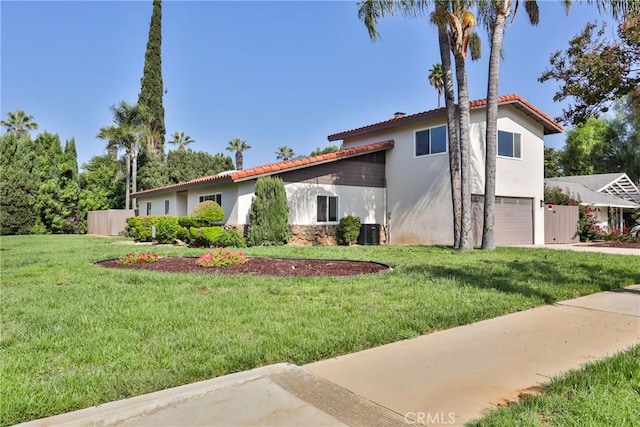 view of front of house featuring central air condition unit, a front lawn, and a garage