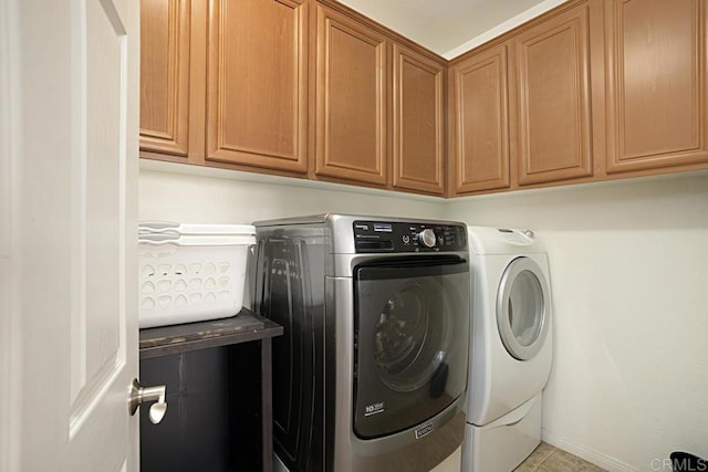 washroom with cabinets and washing machine and clothes dryer