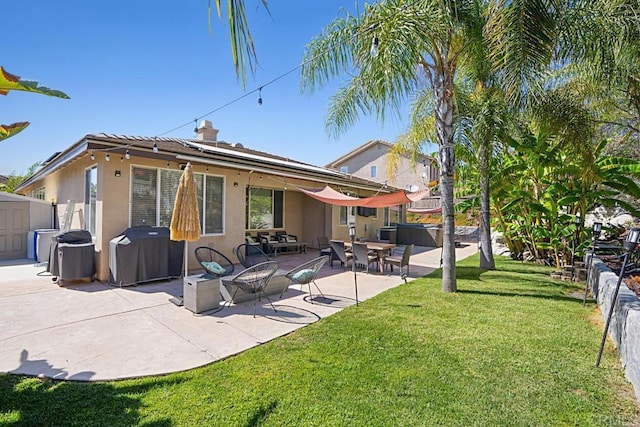 rear view of property featuring a patio, fence, a yard, stucco siding, and a chimney