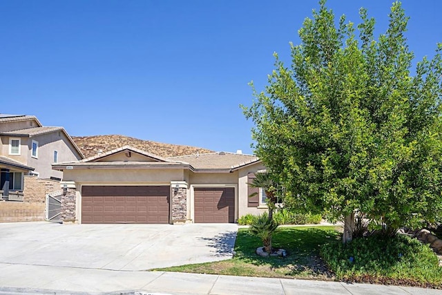 view of front of house featuring a garage, stone siding, concrete driveway, and stucco siding