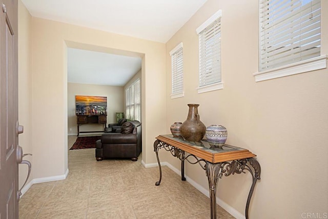 hall with light tile patterned floors and baseboards