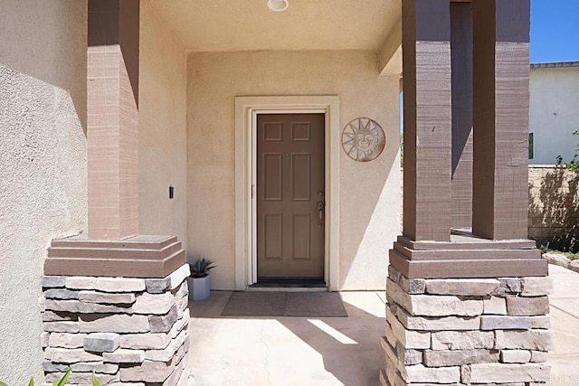 doorway to property featuring stucco siding