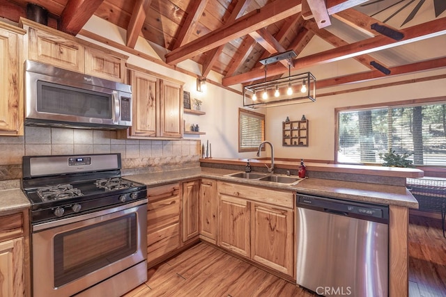 kitchen featuring pendant lighting, sink, light hardwood / wood-style flooring, stainless steel appliances, and vaulted ceiling with beams