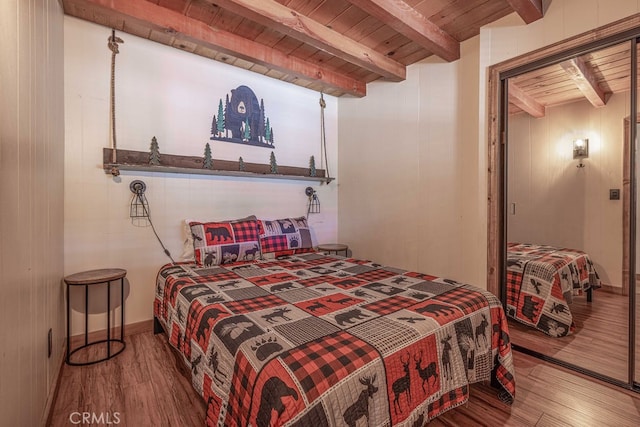 bedroom with hardwood / wood-style flooring, wooden walls, beam ceiling, and wooden ceiling