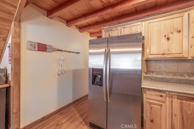 kitchen with wood ceiling, light wood-type flooring, tasteful backsplash, beam ceiling, and stainless steel fridge