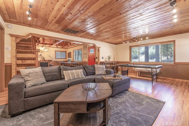 living room with wooden ceiling, rail lighting, wood walls, and hardwood / wood-style flooring