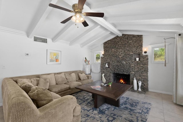 tiled living room with a stone fireplace, a wealth of natural light, ceiling fan, and vaulted ceiling with beams