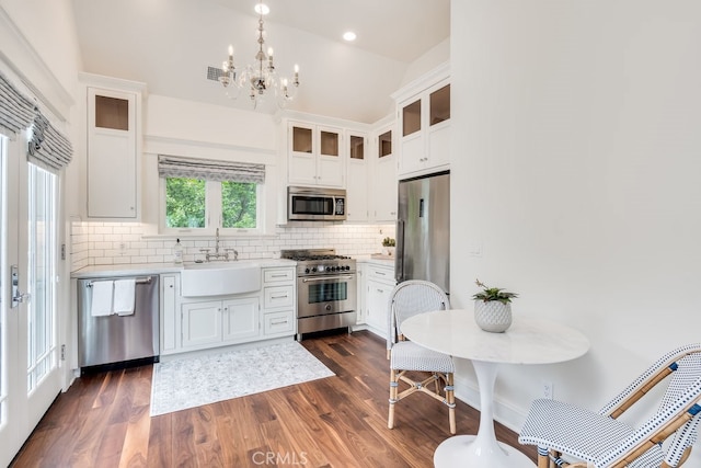 kitchen with white cabinets, sink, appliances with stainless steel finishes, dark hardwood / wood-style floors, and decorative backsplash