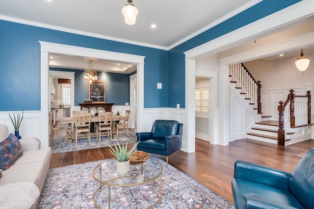 living room featuring an inviting chandelier, dark hardwood / wood-style floors, and ornamental molding