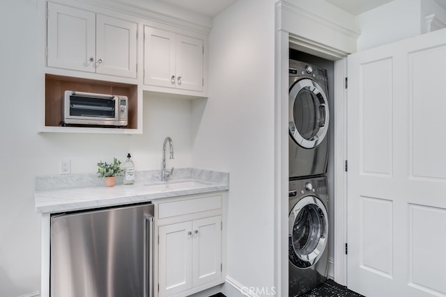 laundry room featuring stacked washer and dryer and sink