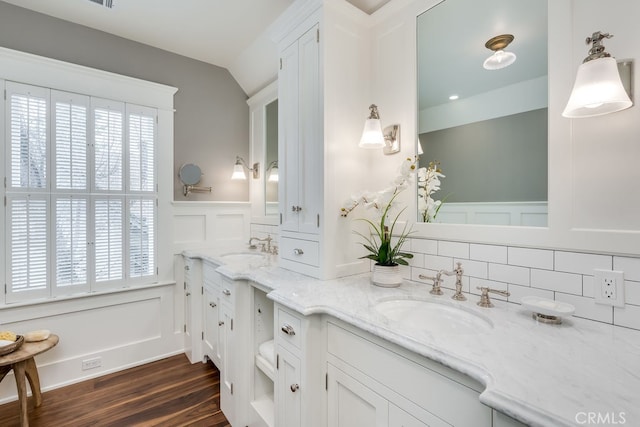 bathroom with lofted ceiling, a wealth of natural light, hardwood / wood-style floors, and vanity