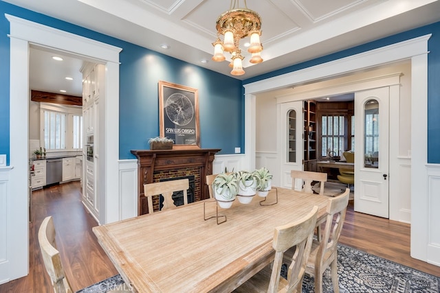 dining space featuring a notable chandelier, beam ceiling, coffered ceiling, and dark hardwood / wood-style flooring