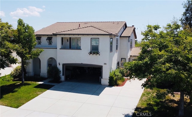 mediterranean / spanish house featuring a front yard and a garage