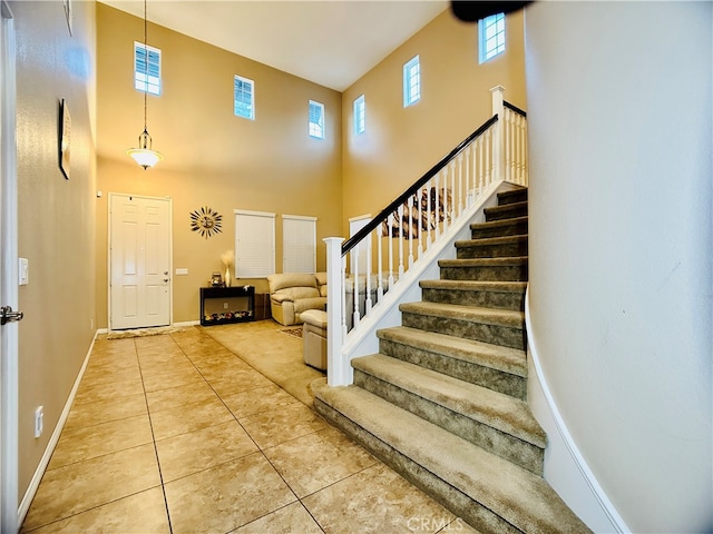 entryway featuring a high ceiling and tile patterned flooring