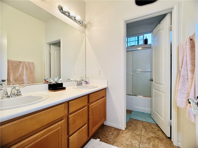 bathroom featuring vanity and bath / shower combo with glass door